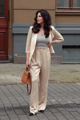 a lady in a striped top, a blazer and a pair of full-length pants
